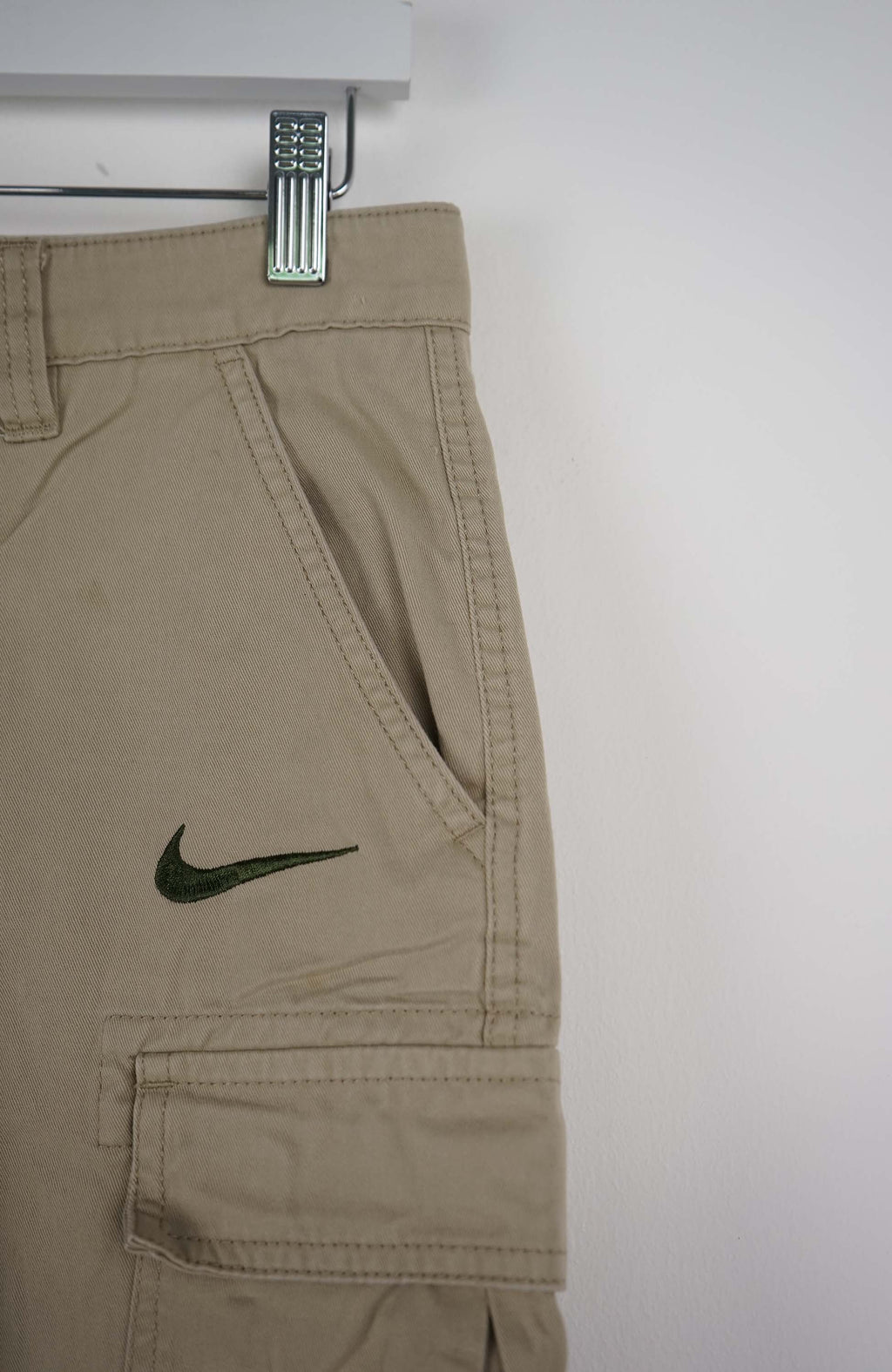 Beige cargo shorts with Nike logo on a white background
