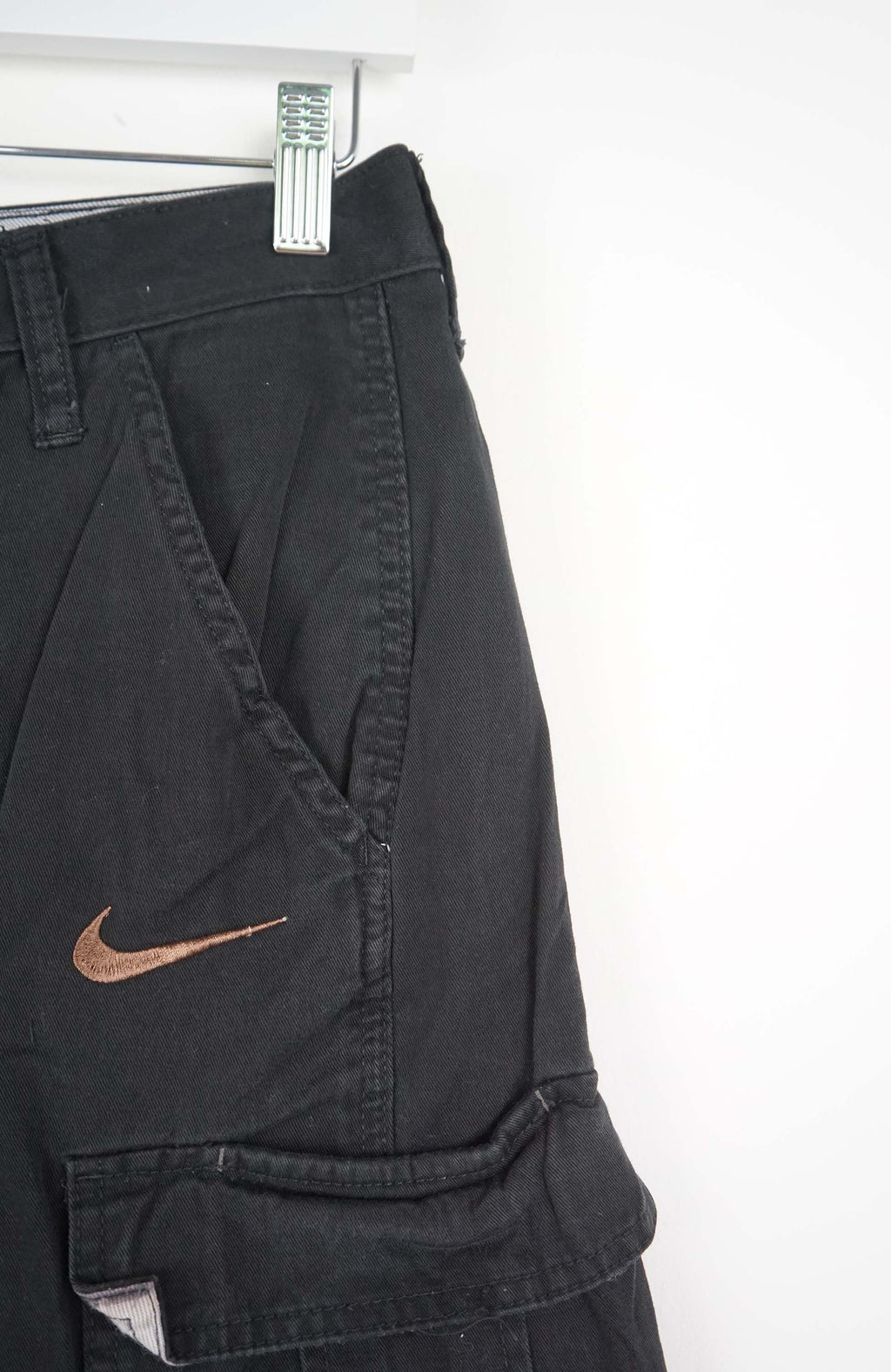 Black cargo shorts with a Nike logo on a white background