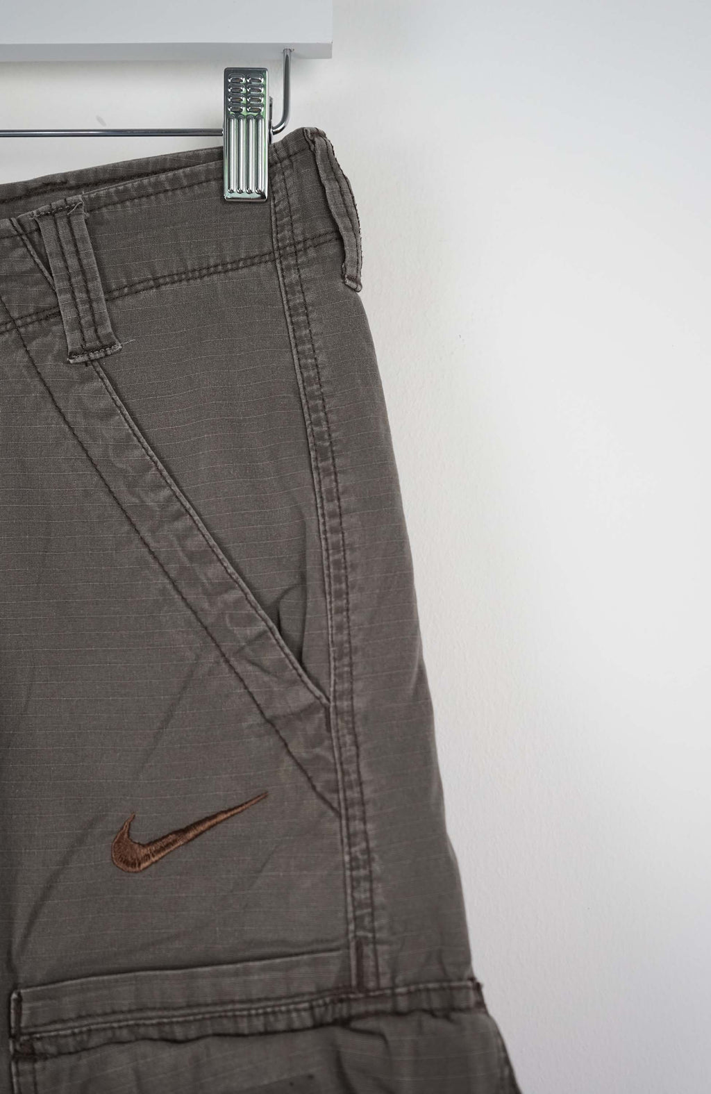 Brown cargo shorts with a Nike logo on a white background