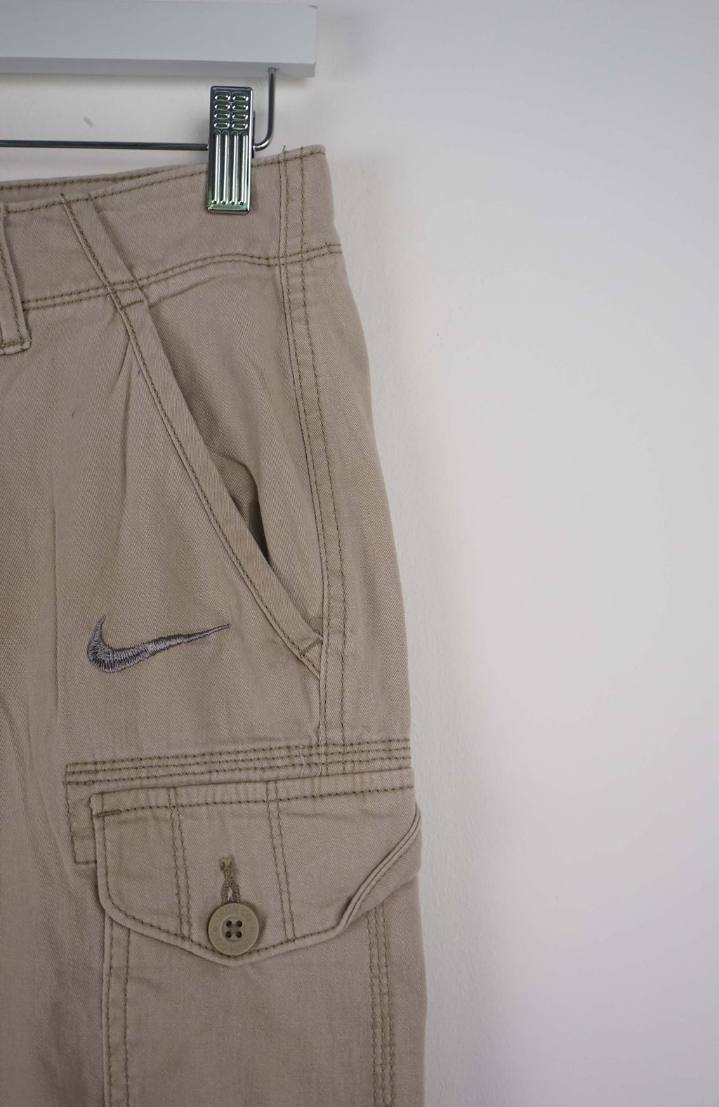 Beige cargo shorts with a Nike logo on a white background