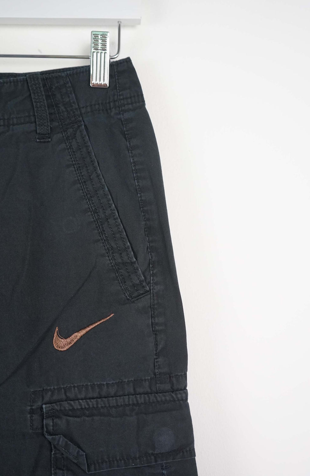 Black cargo shorts with a Nike logo on a white background