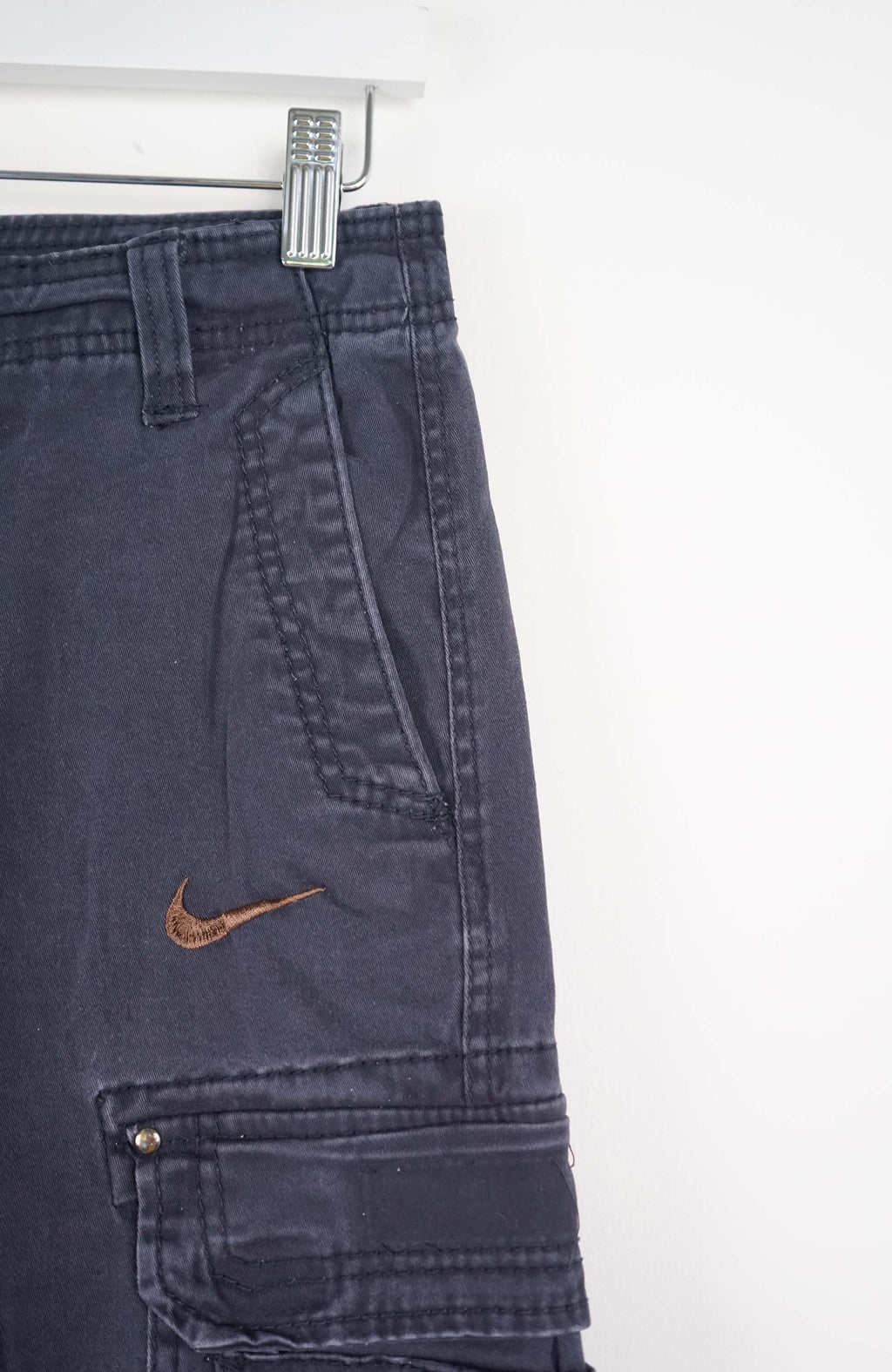 Blue cargo shorts with a Nike logo on a white background