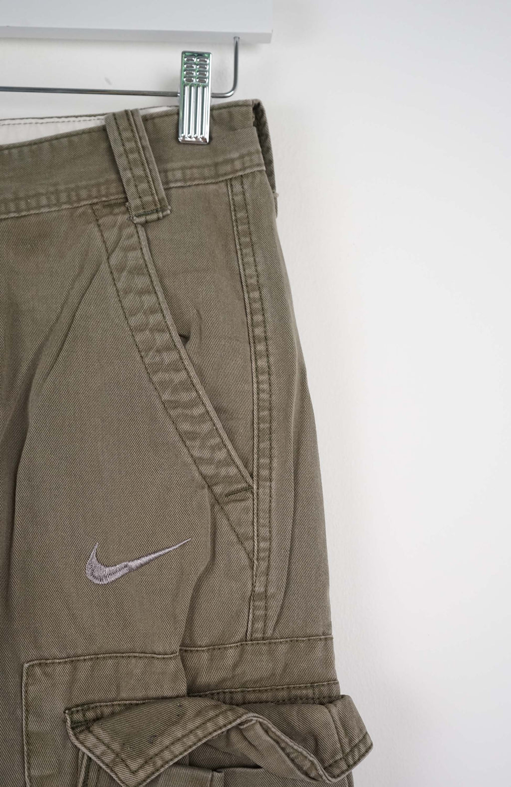 Khaki cargo shorts with a Nike logo on a white background