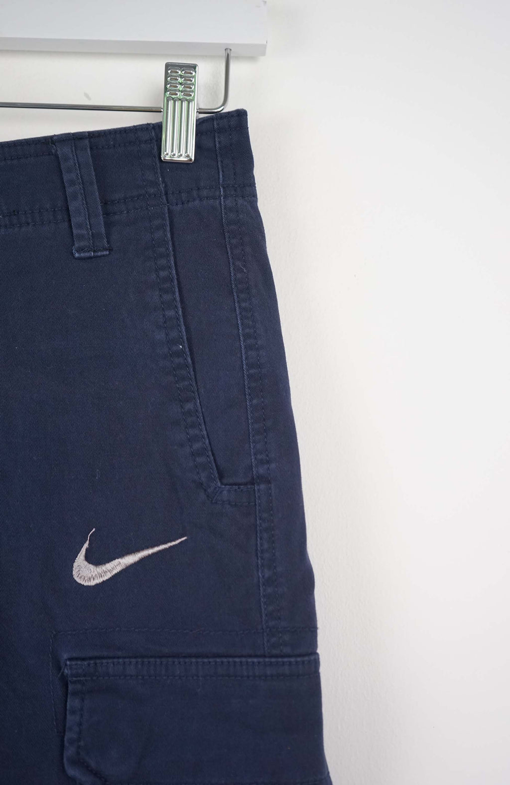 Blue cargo shorts with a Nike logo on a white background