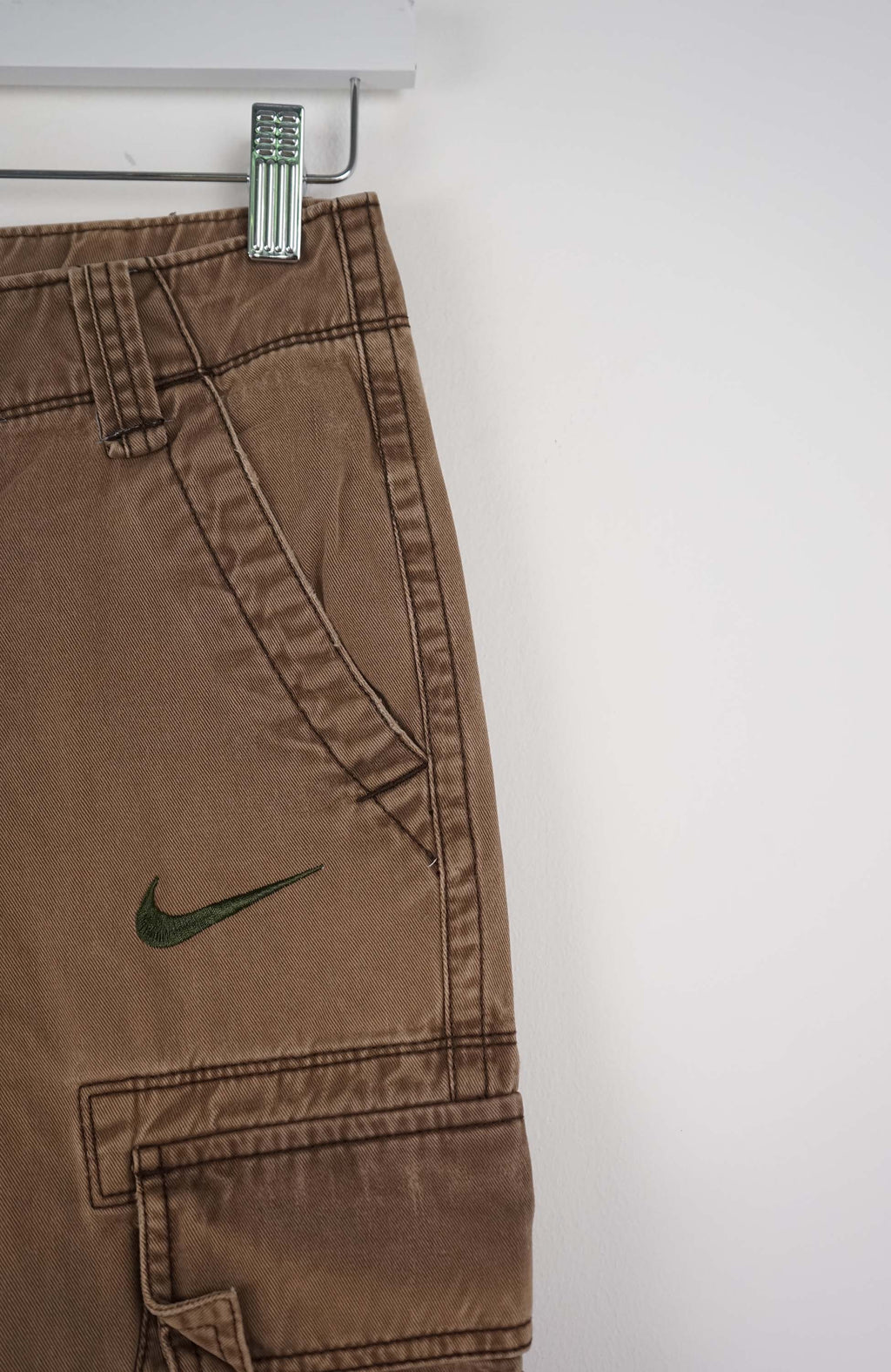 Brown cargo shorts with a Nike logo on a white background