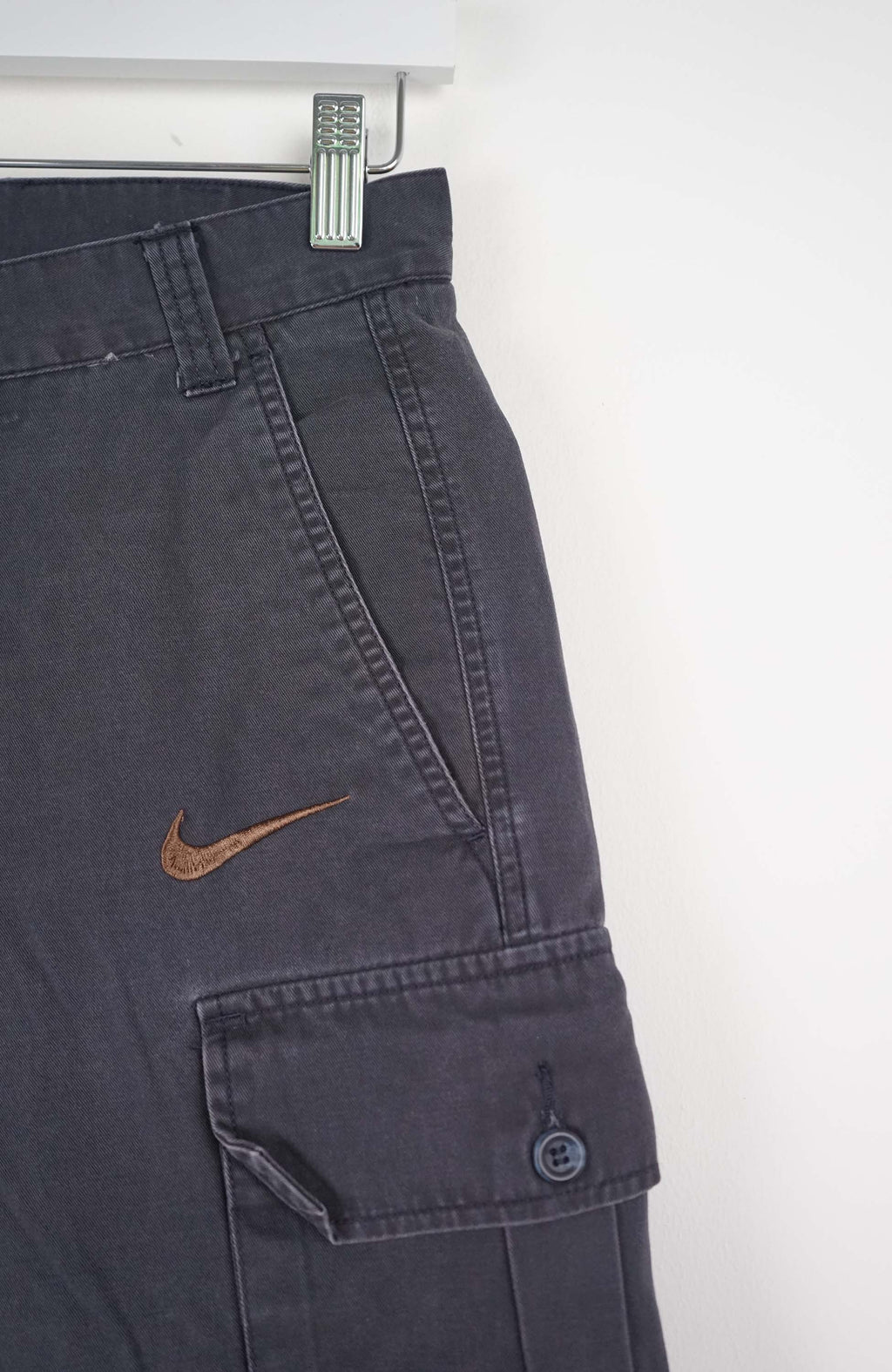 Gray cargo shorts with a Nike logo on a white background