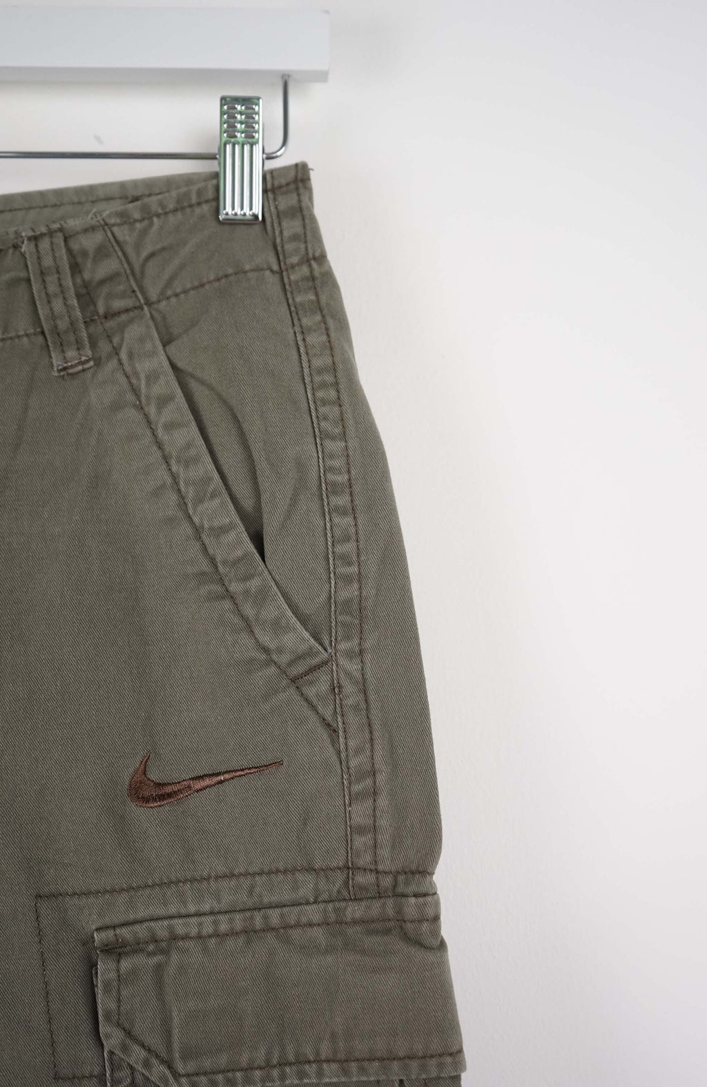 Green cargo shorts with a Nike logo on a white background