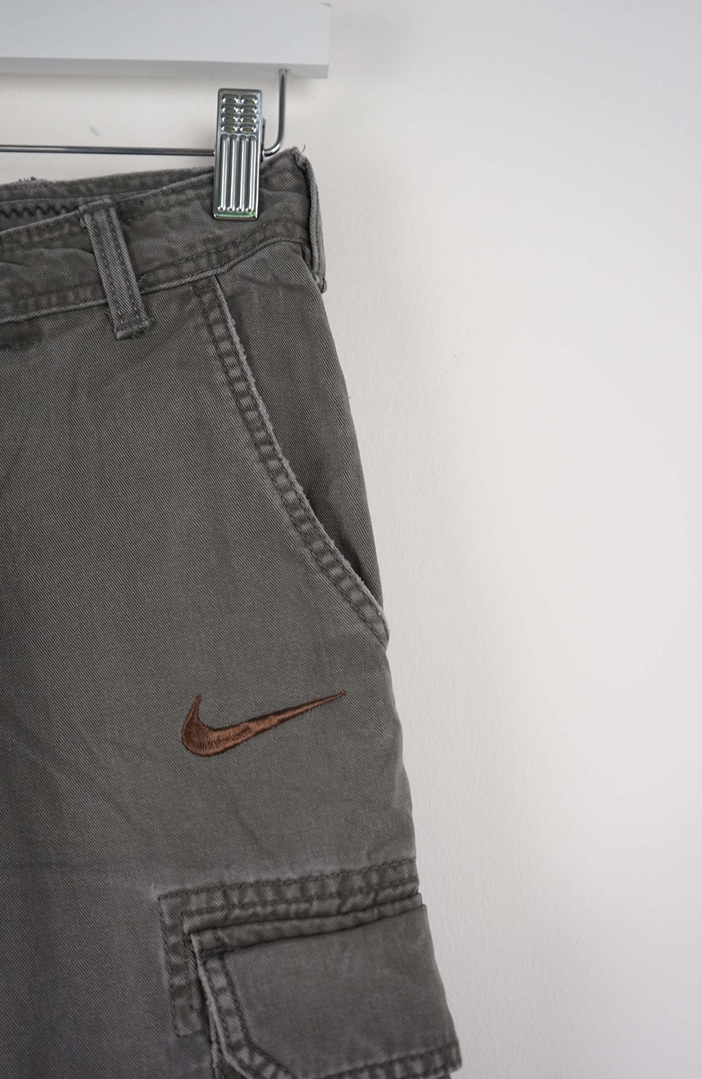Gray cargo shorts with a Nike logo on a white background