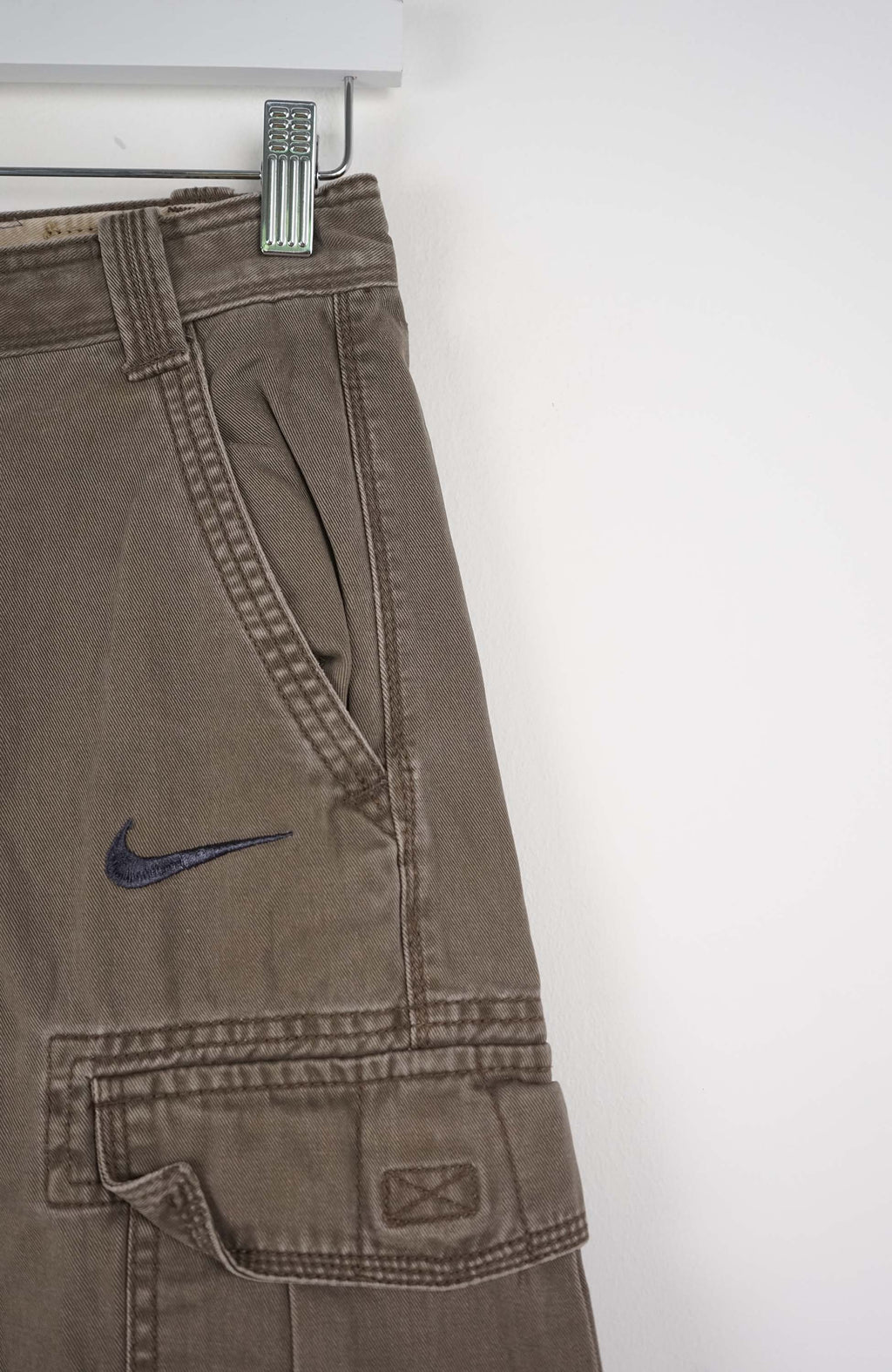 Brown cargo shorts with a Nike logo on a white background