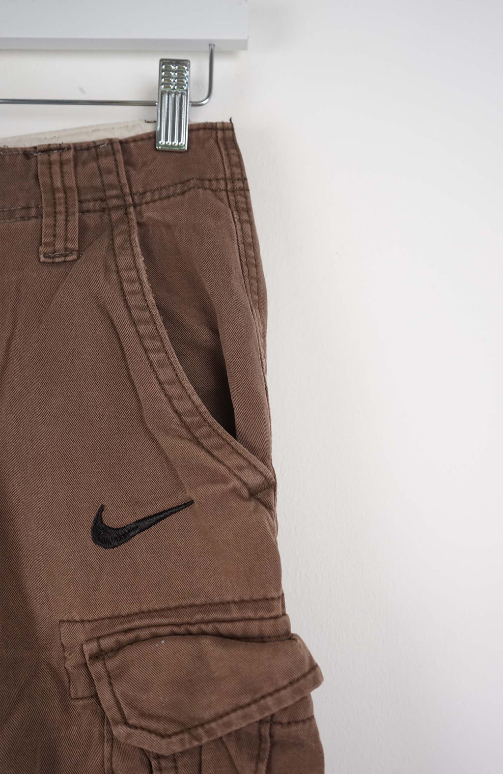 Brown cargo shorts with a Nike logo on a white background