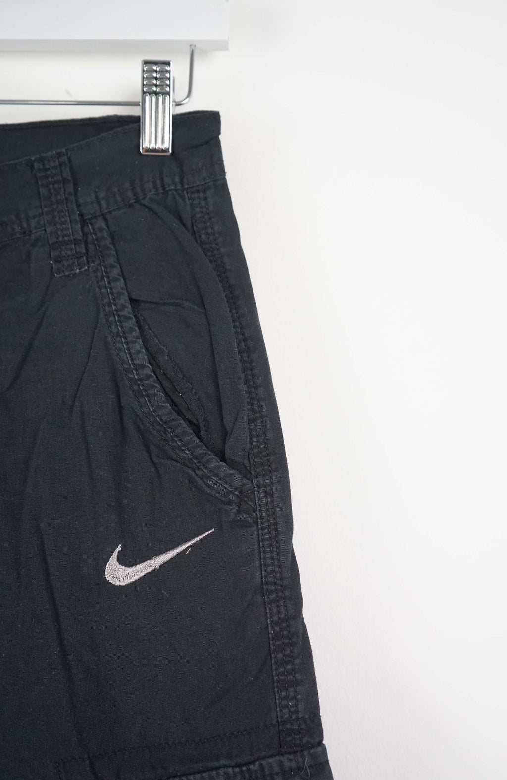 Black cargo shorts with a Nike logo on a white background