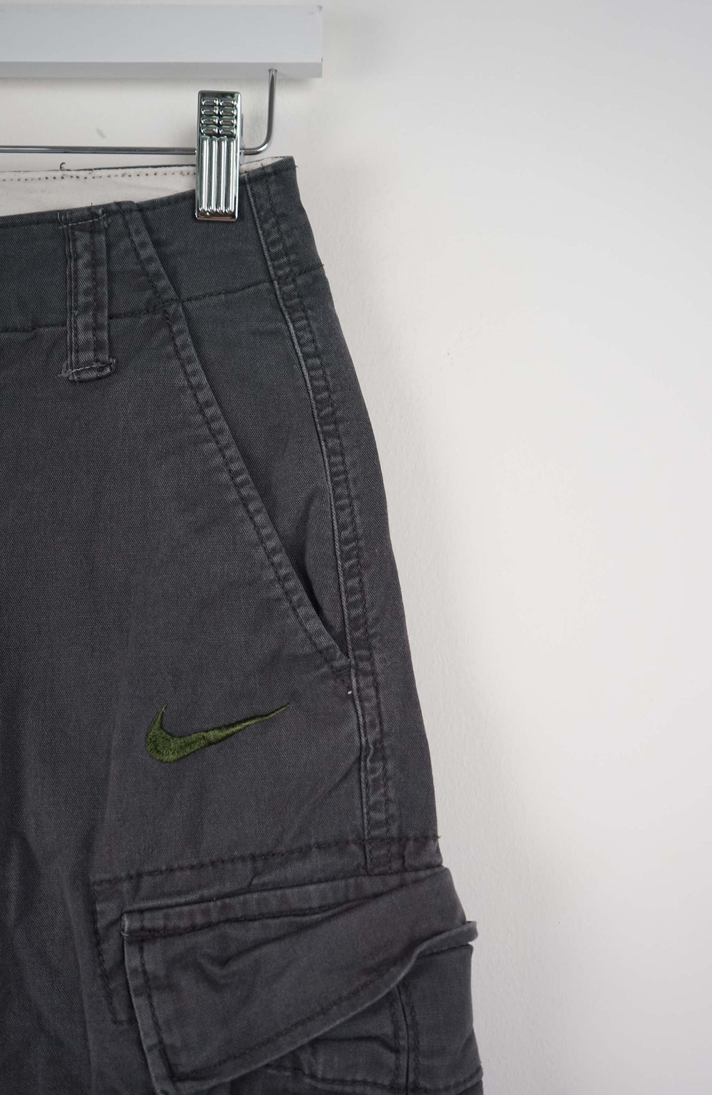 Gray cargo shorts on a white hanger against a white background
