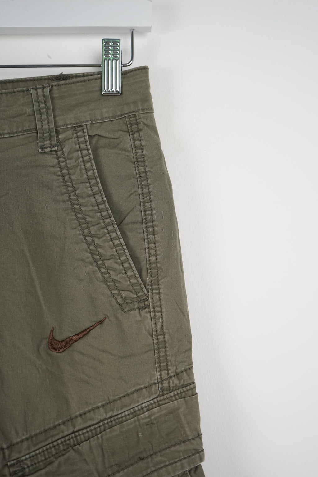 Green cargo shorts with a Nike logo on a white background
