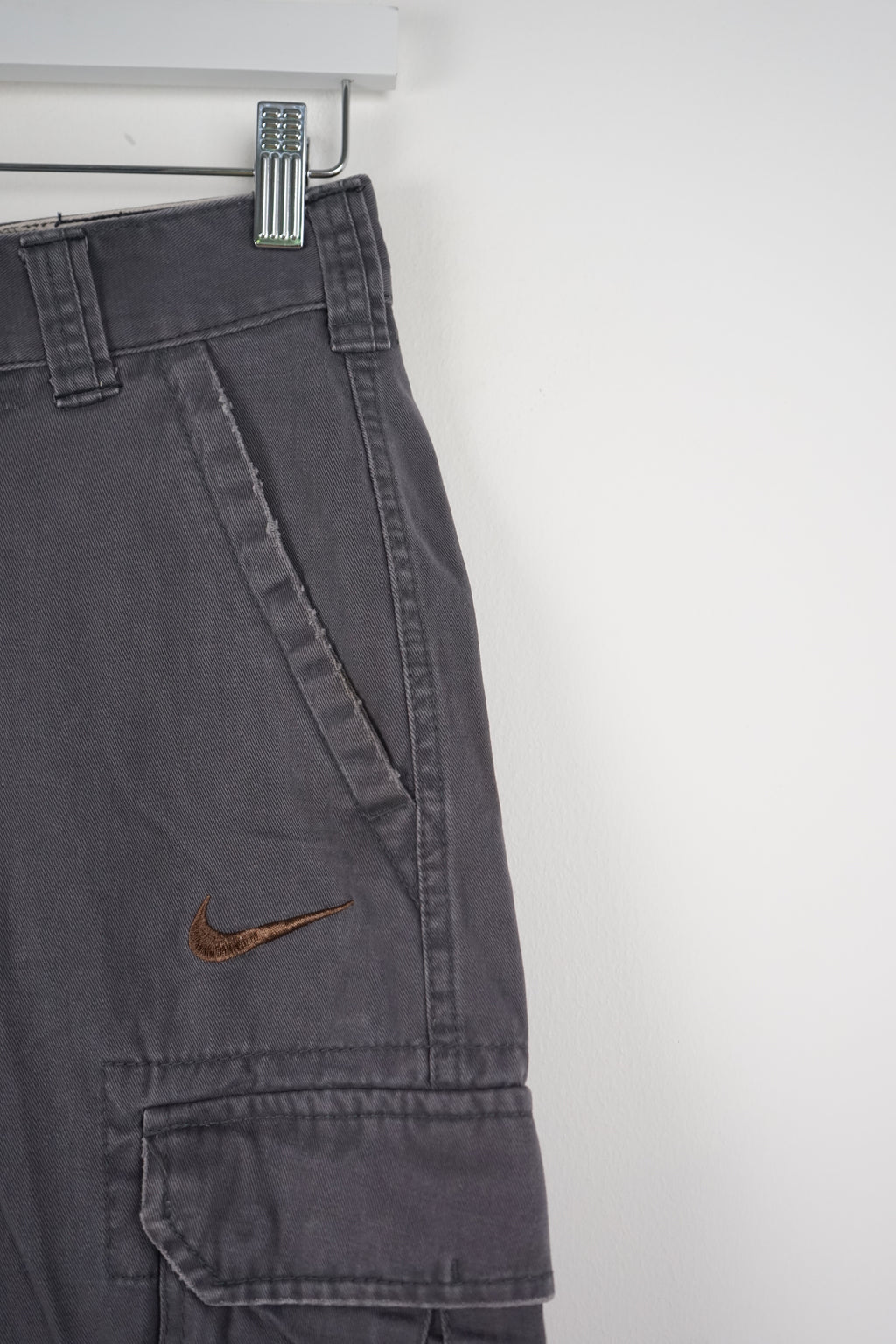 Gray cargo shorts with a Nike logo on a white background