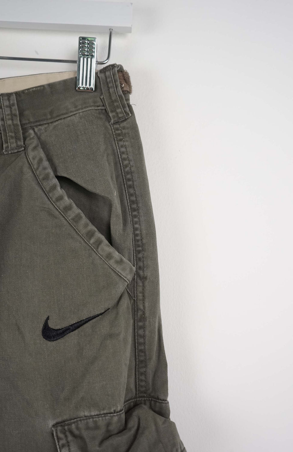 Green cargo shorts with a Nike logo on a white background