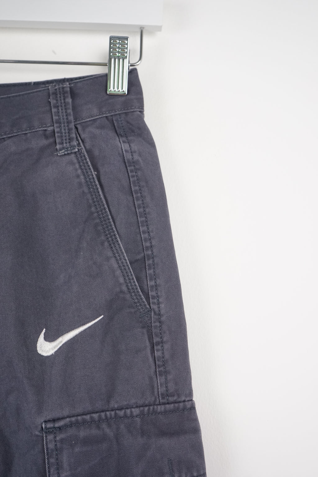 Gray cargo shorts with a Nike logo on a white background