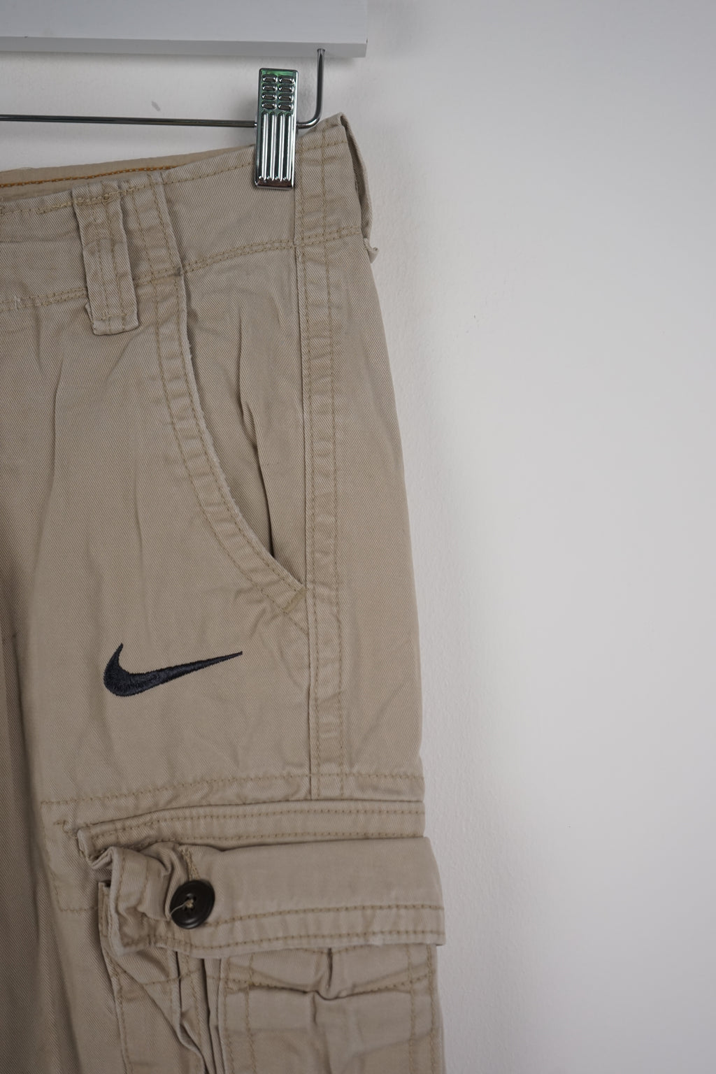Beige cargo shorts with a Nike logo on a white background