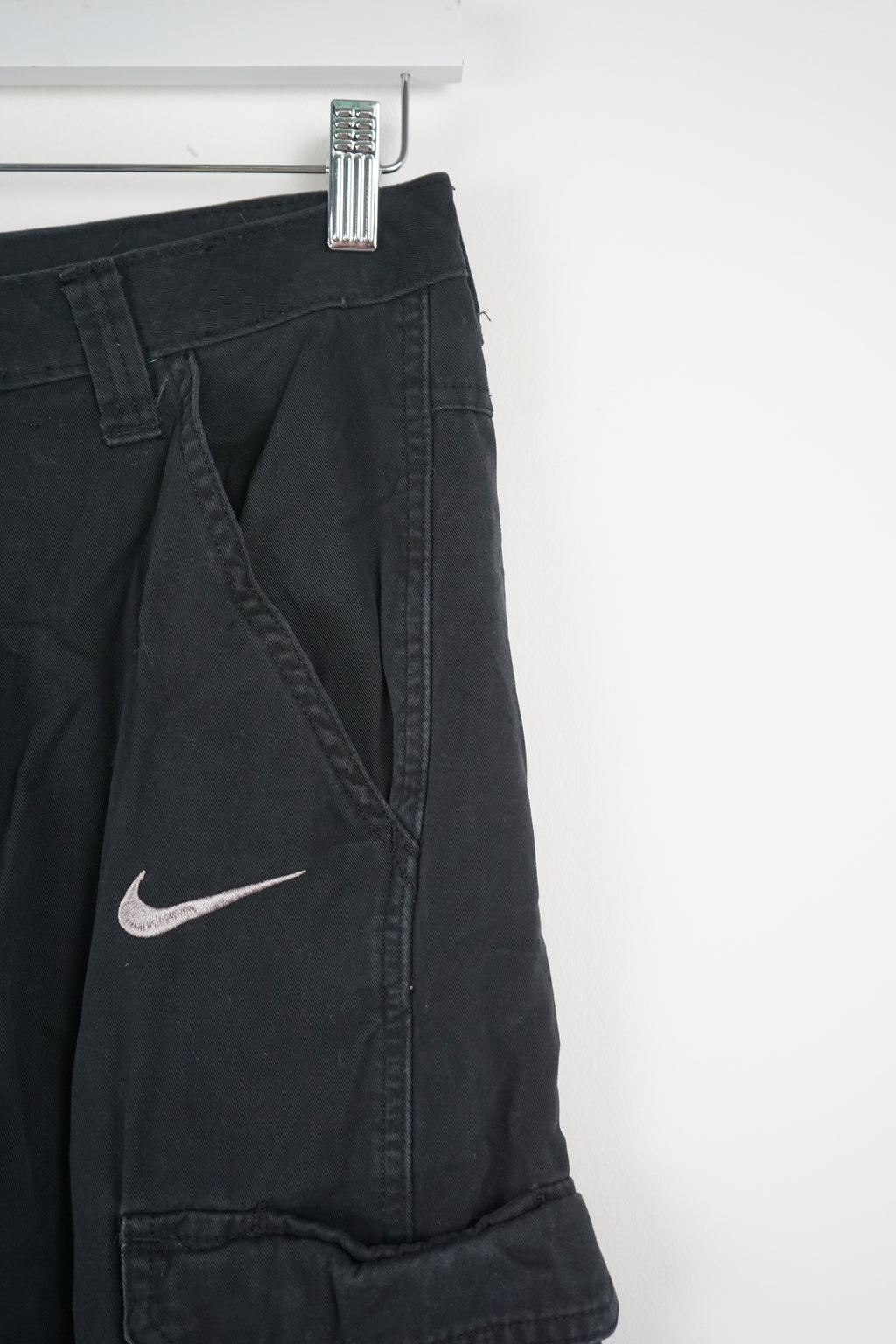 Black cargo shorts with a Nike logo on a white background