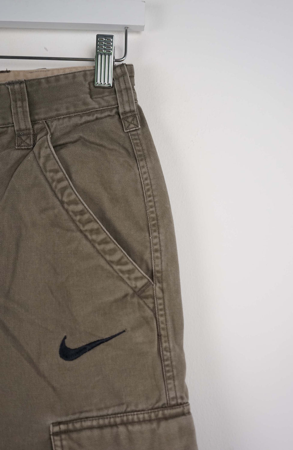 Beige cargo shorts with a Nike logo on a white background