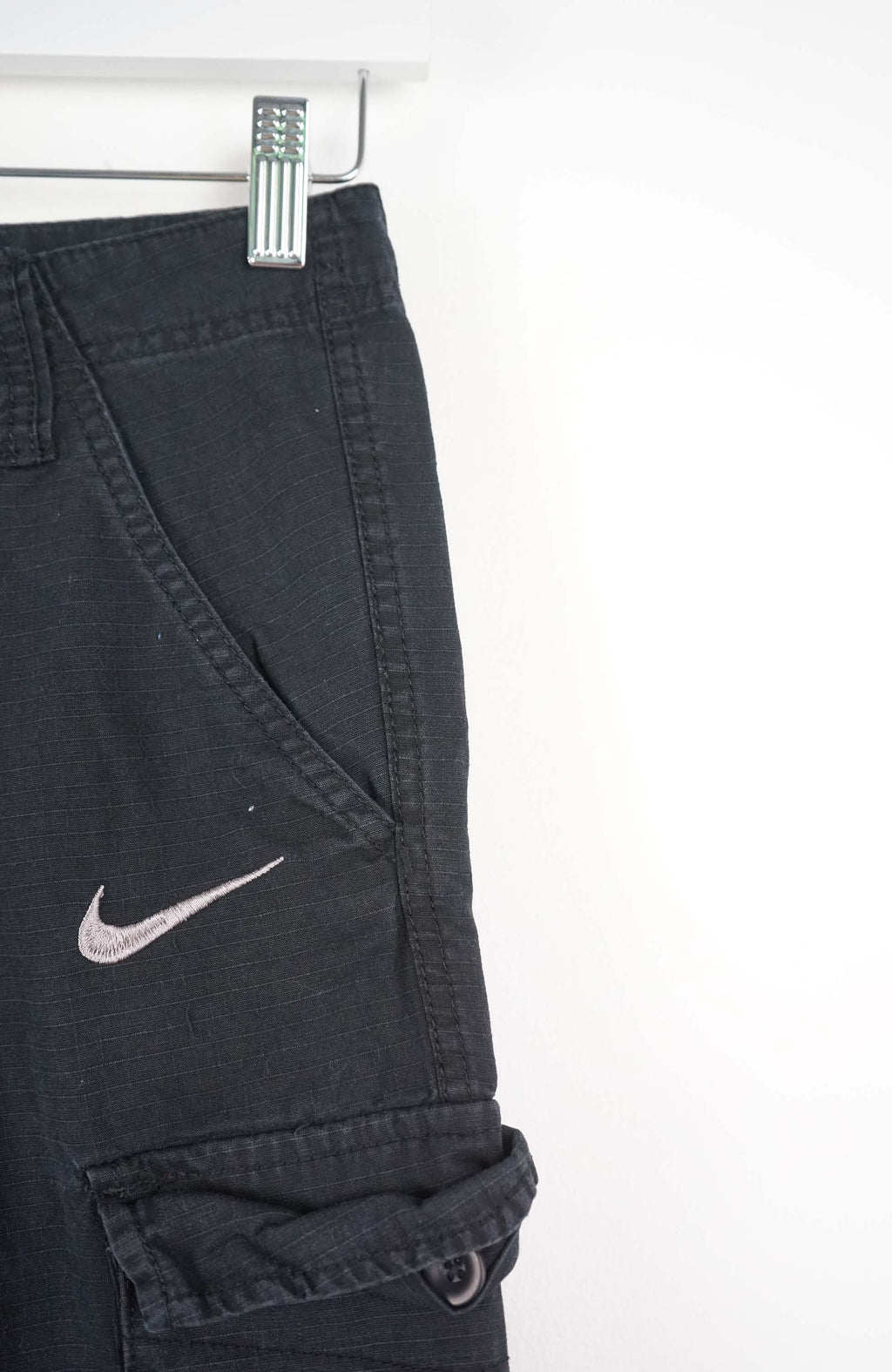 Black cargo shorts with a Nike logo on a white background