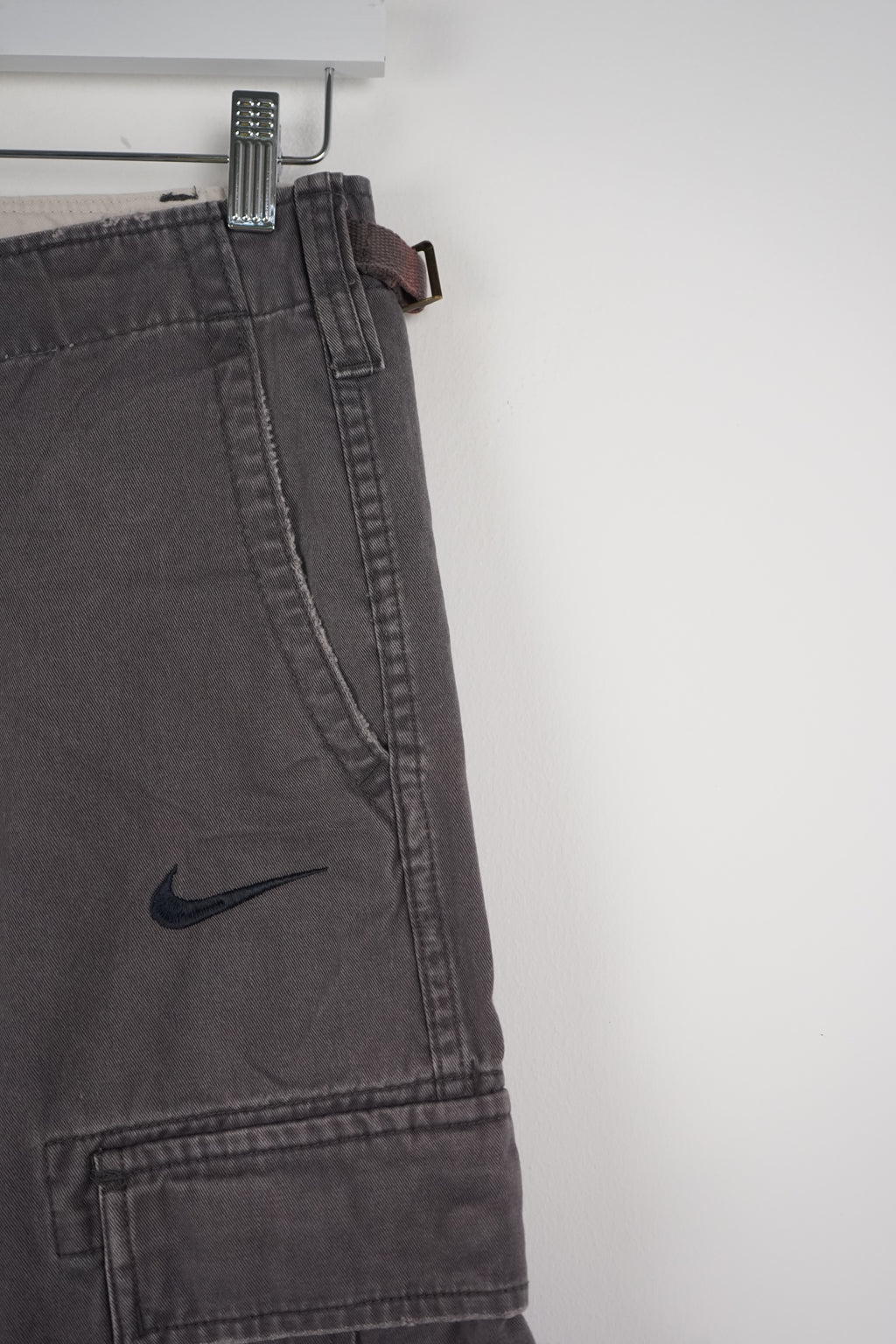 Gray cargo shorts with a Nike logo on a white background