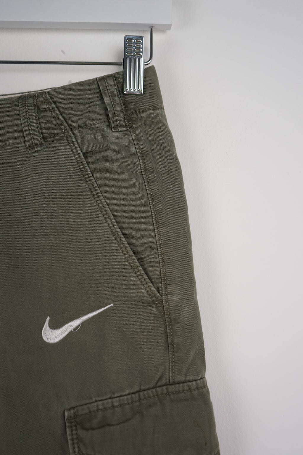 Green cargo shorts with Nike logo on a white background