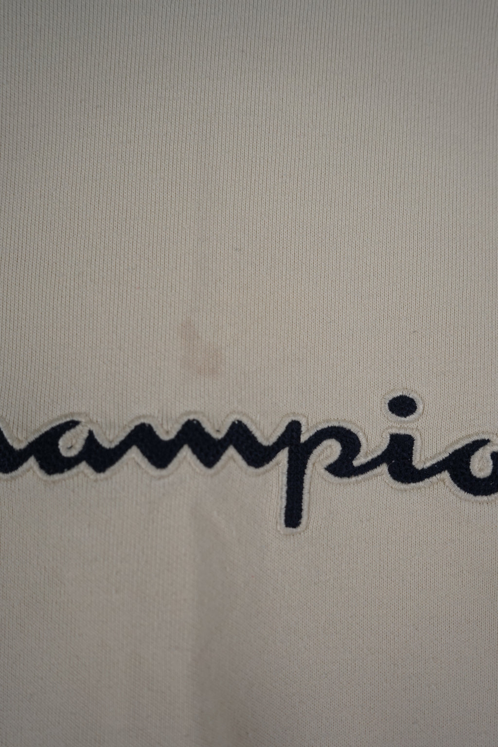 Beige sweatshirt with Champion logo on a white background