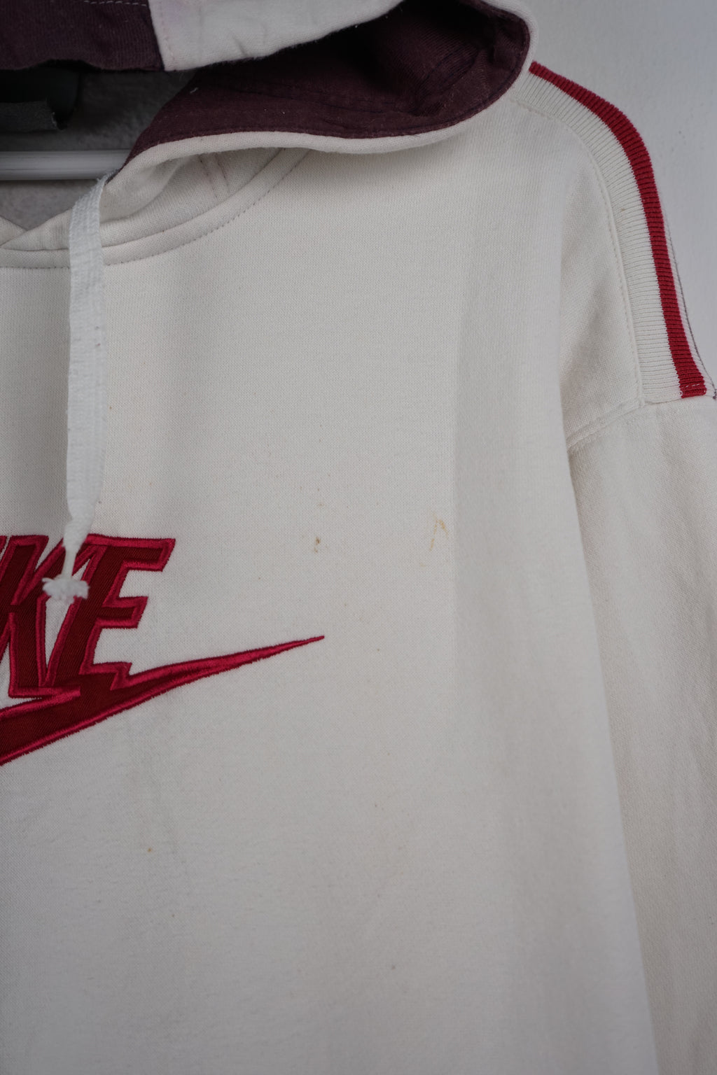 White hoodie with red Nike logo on a white background