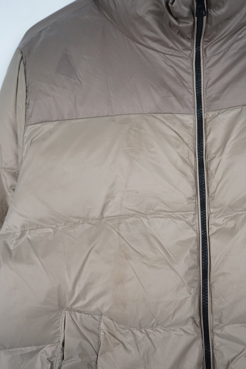Beige puffer jacket on a white background