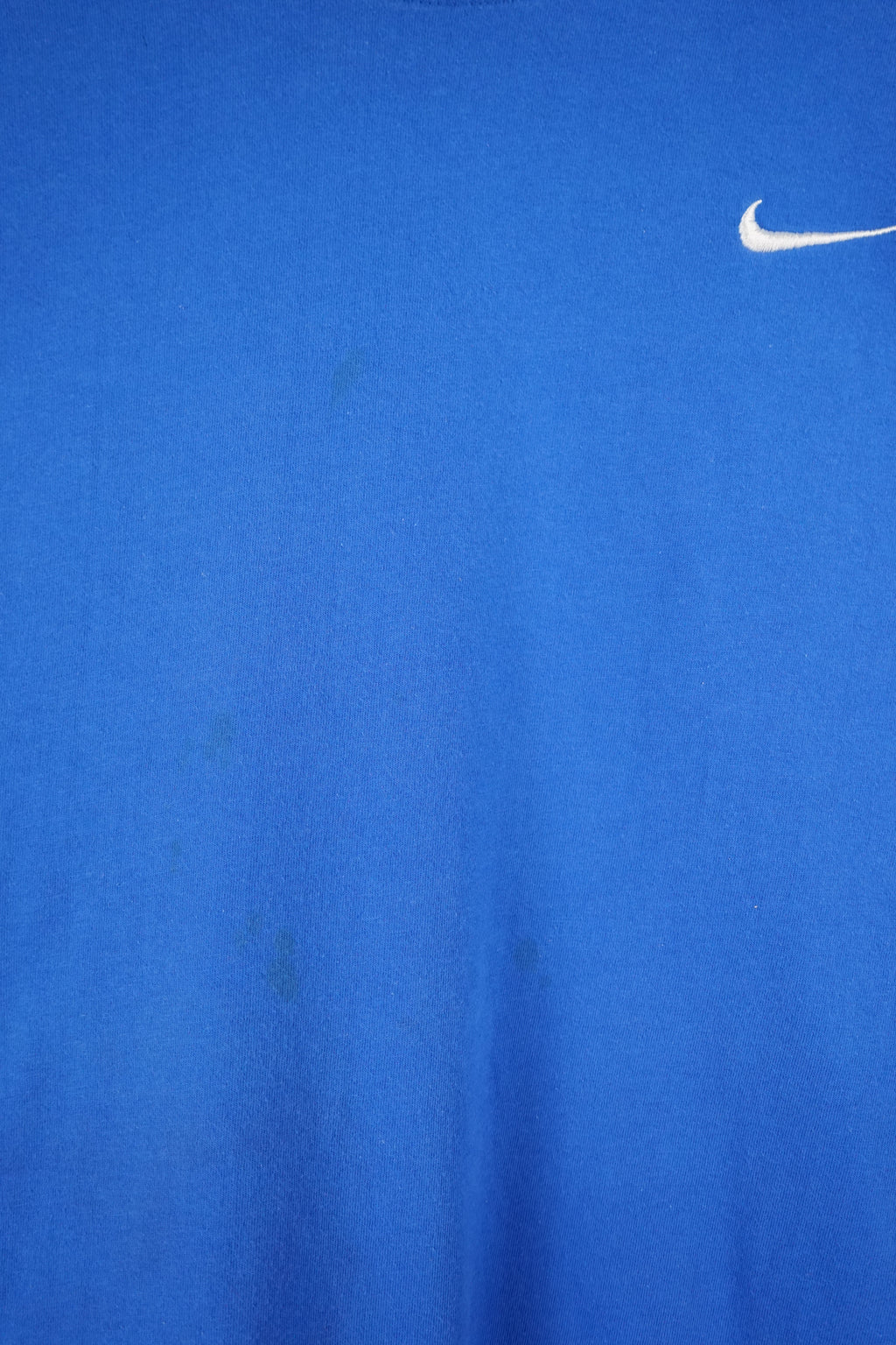 Blue Nike t-shirt on a white hanger against a white background