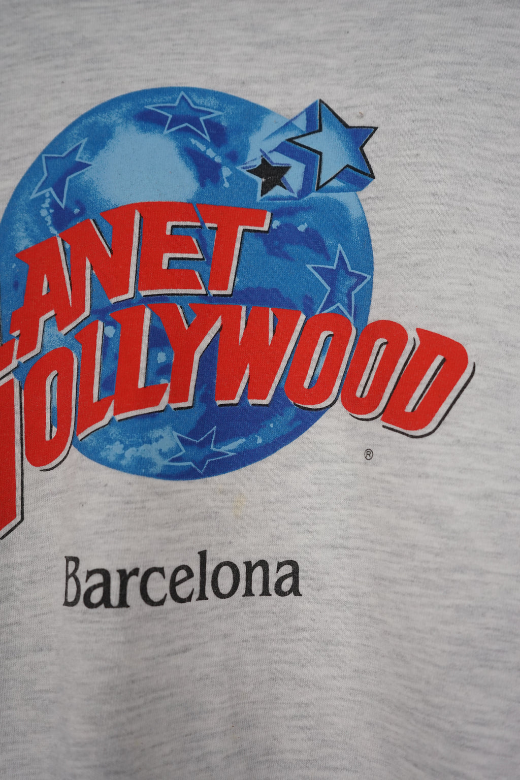 Gray t-shirt with 'Planet Hollywood Barcelona' logo on a white background