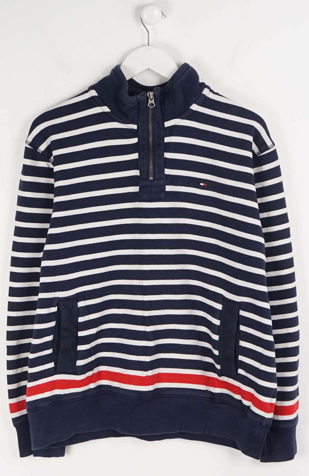 Navy and white striped sweater with a red stripe on a hanger against a white background