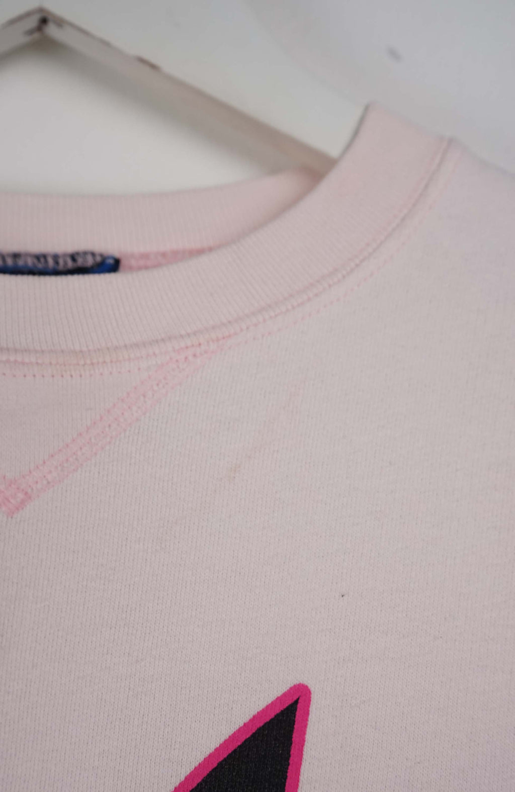 Pink sweatshirt with Playboy bunny logo on a white background