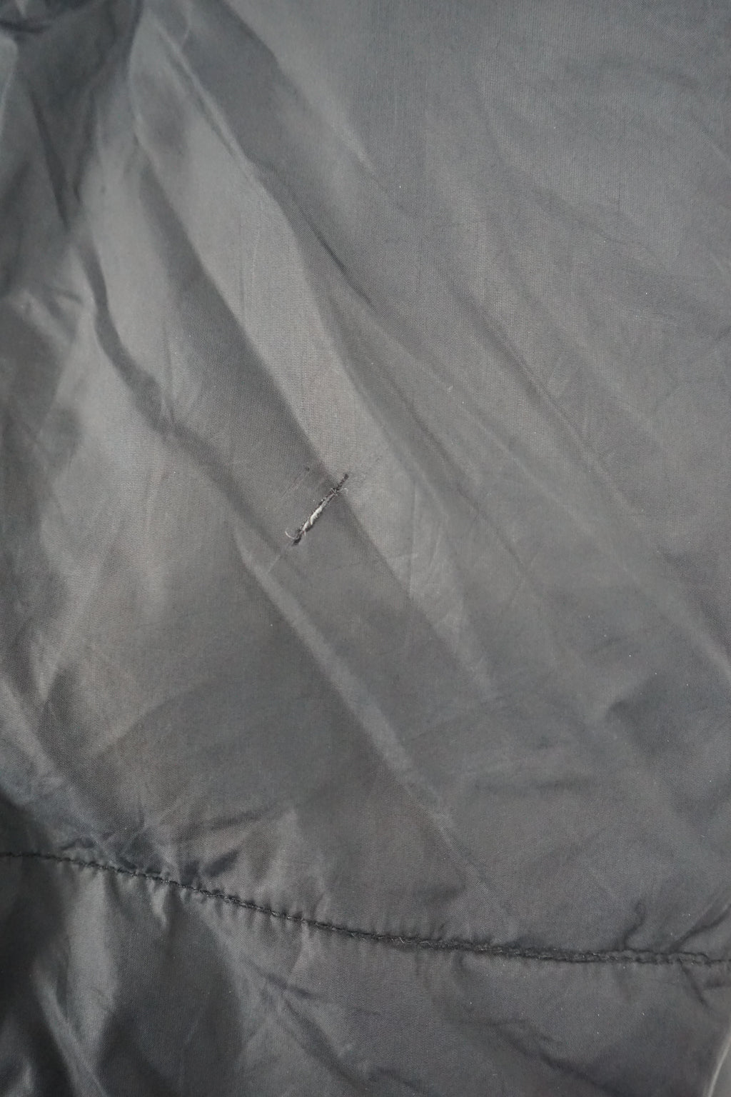 Black puffer jacket with a brand logo on a white background