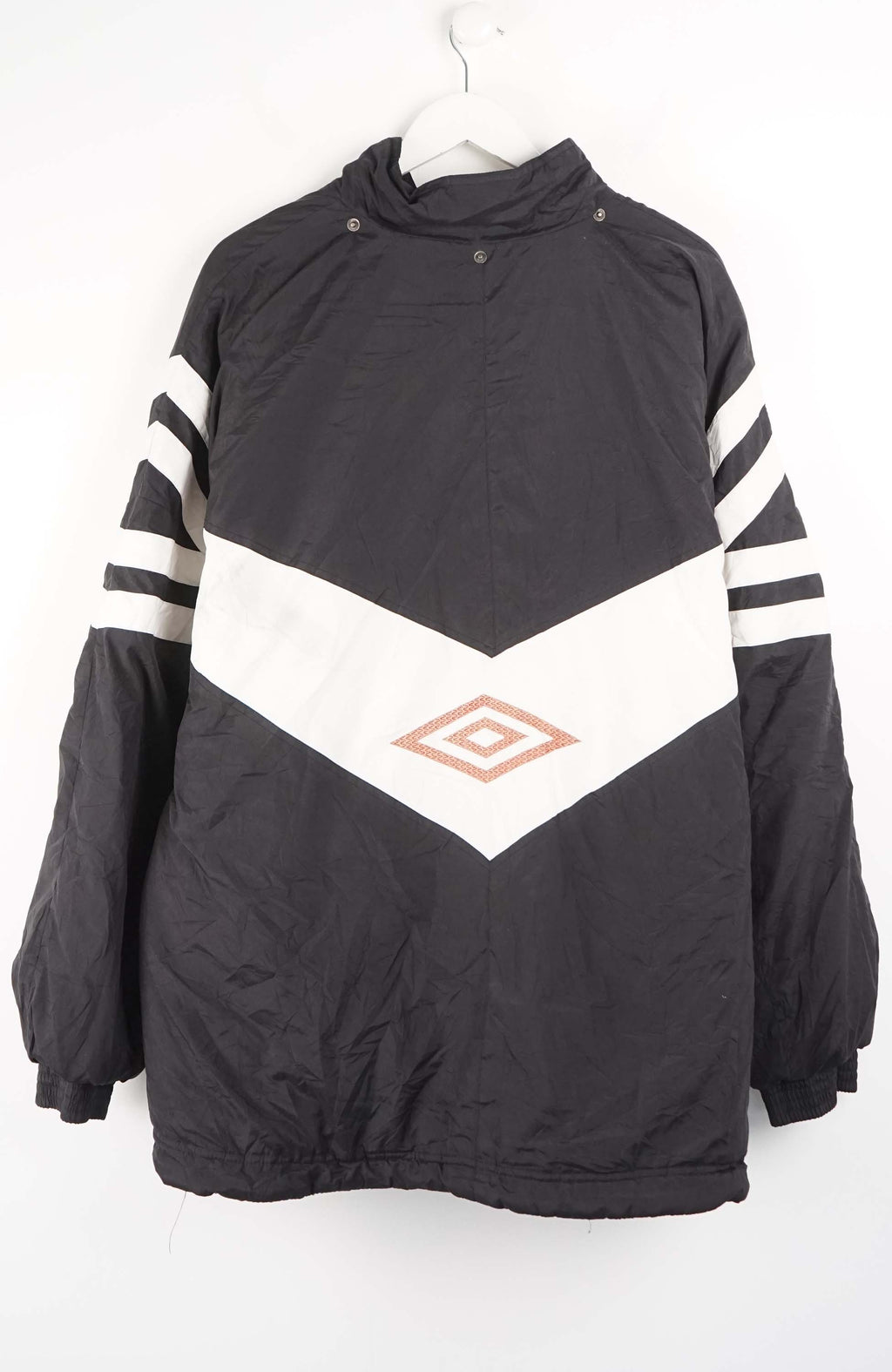 Black and white jacket with striped sleeves on a hanger against a white background