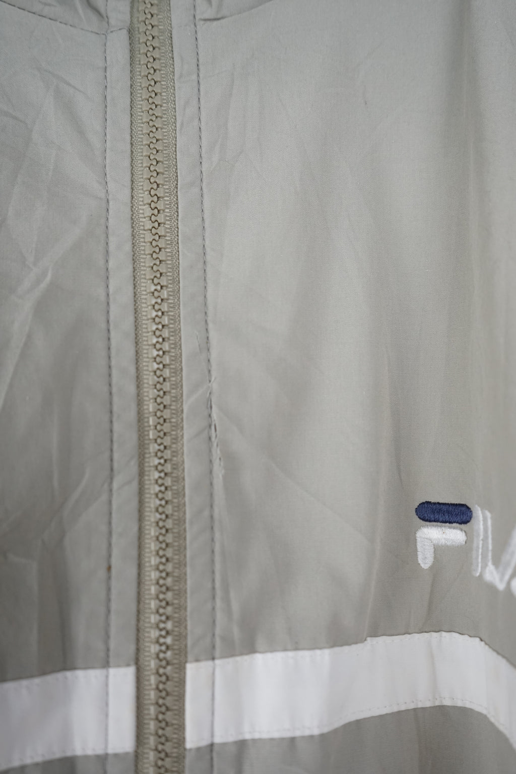 Beige jacket with white and blue accents on a white background