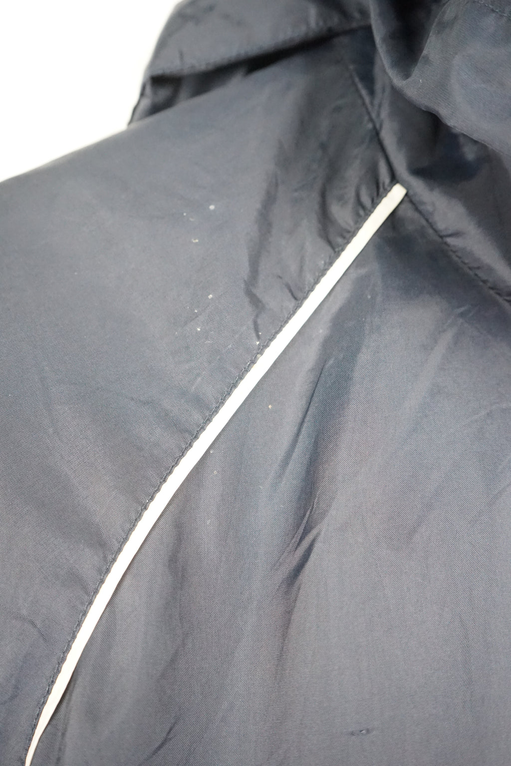 Navy raincoat with white accents on a white background