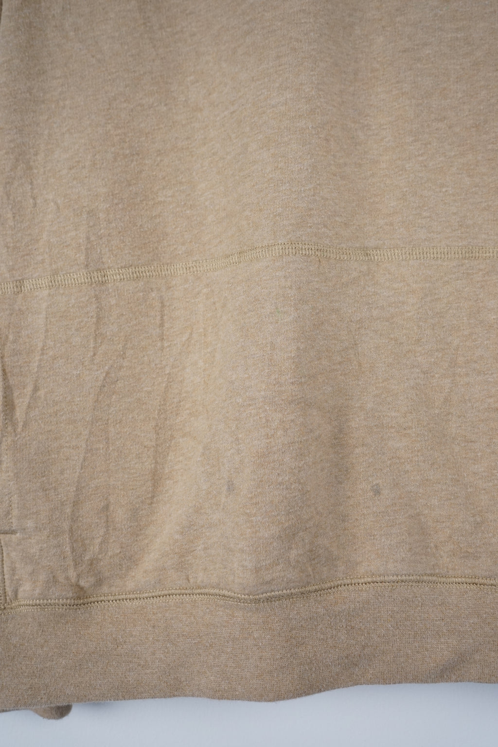 Beige pullover with a small logo on a white background