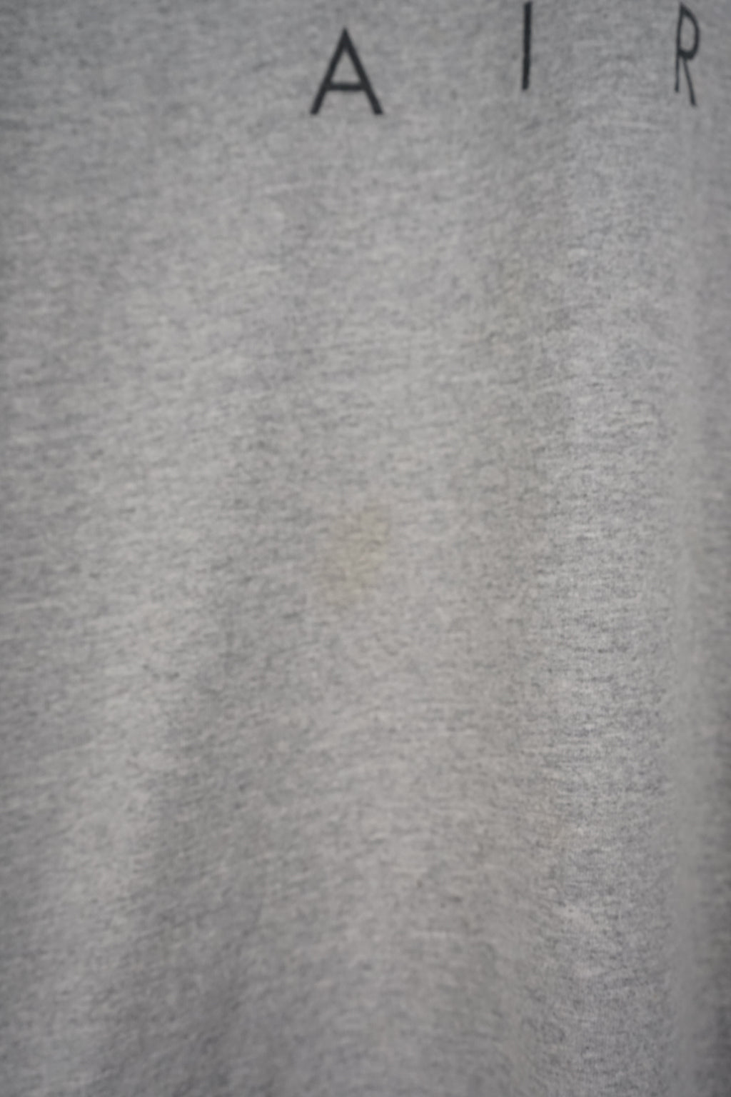 Gray sleeveless Nike shirt with black logo on a white background