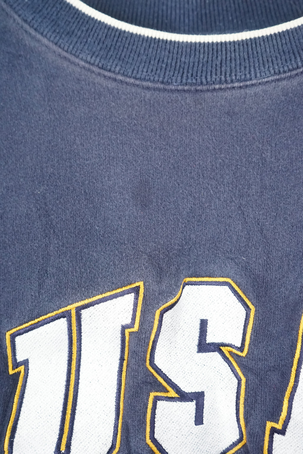 Navy blue sweatshirt with 'USA' and American flag on a white background