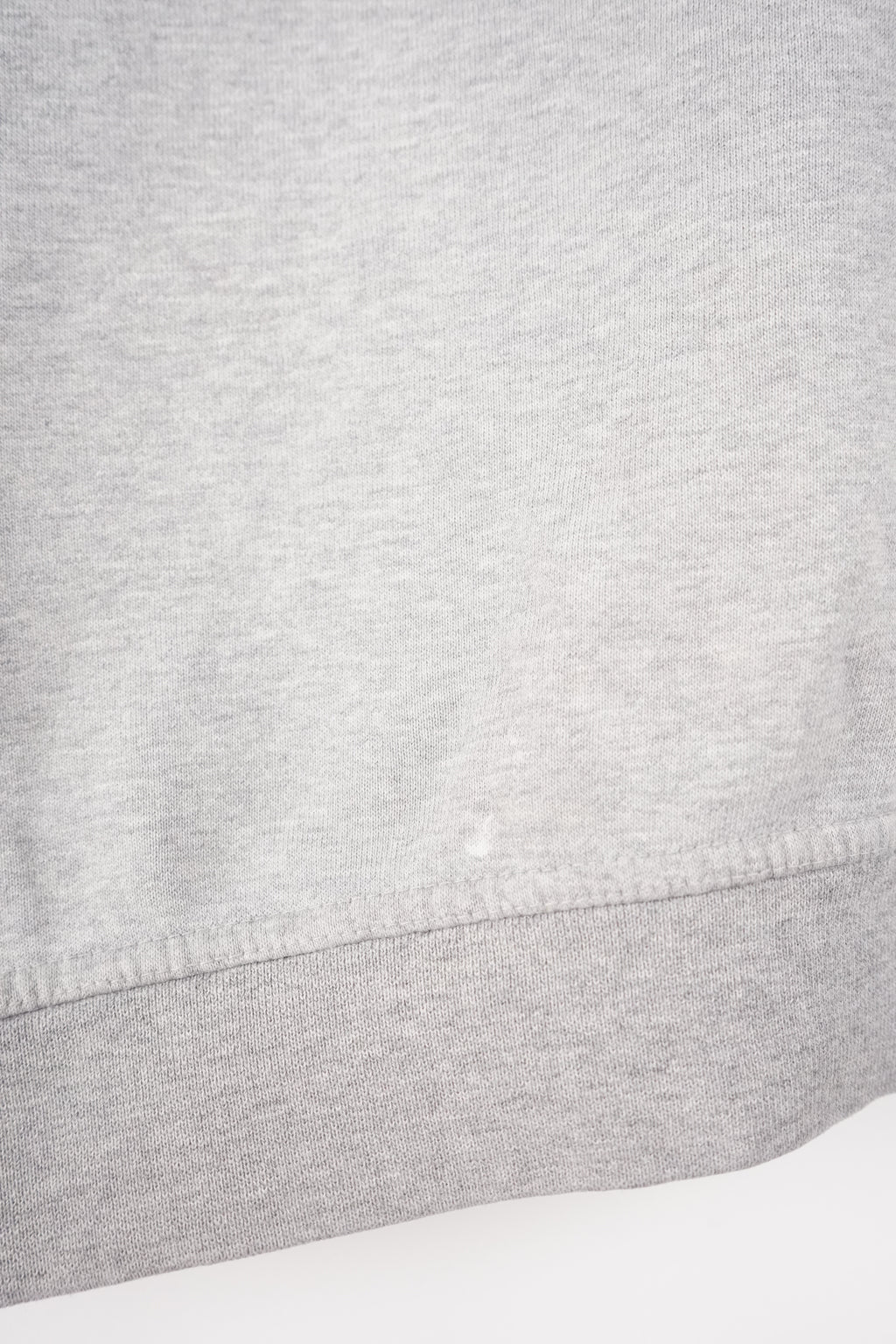 Gray sweatshirt with a brand logo on a white hanger