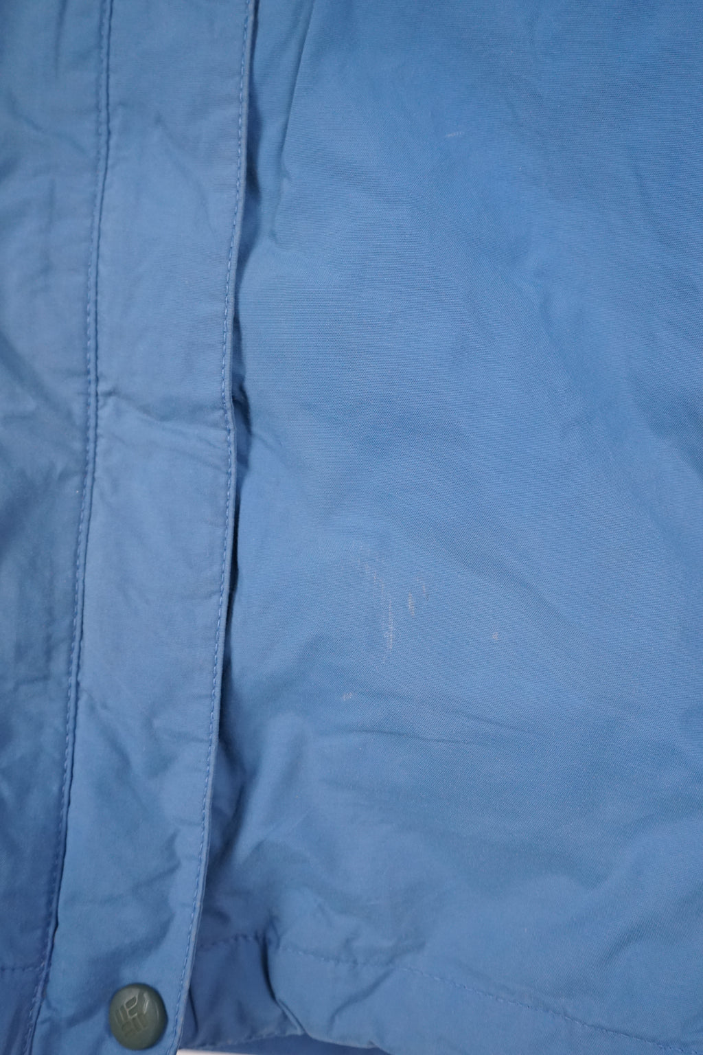 Blue jacket with white accents on a hanger against a white background