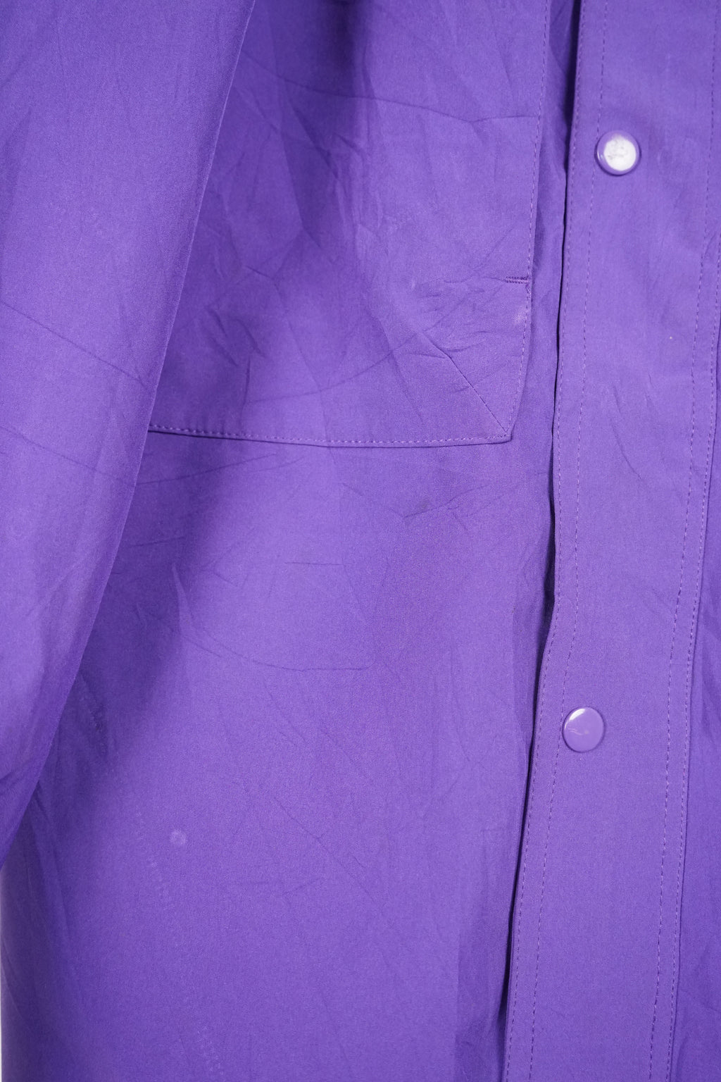 Two-tone teal and purple jacket with a brand logo on a white background