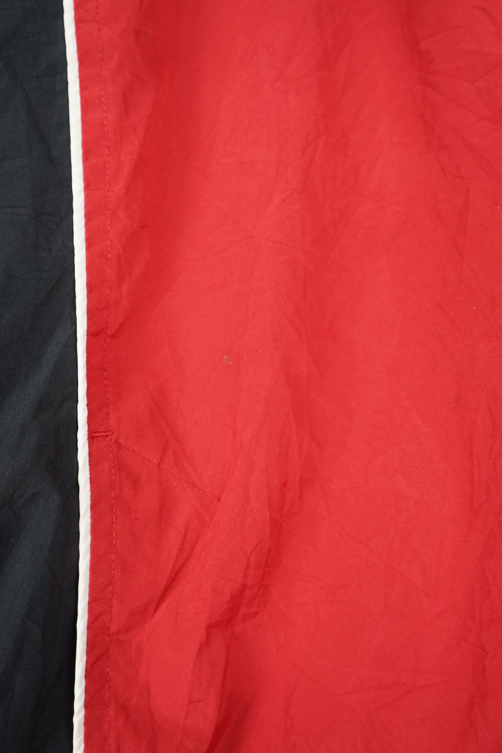Red hooded jacket with black panels on a white background