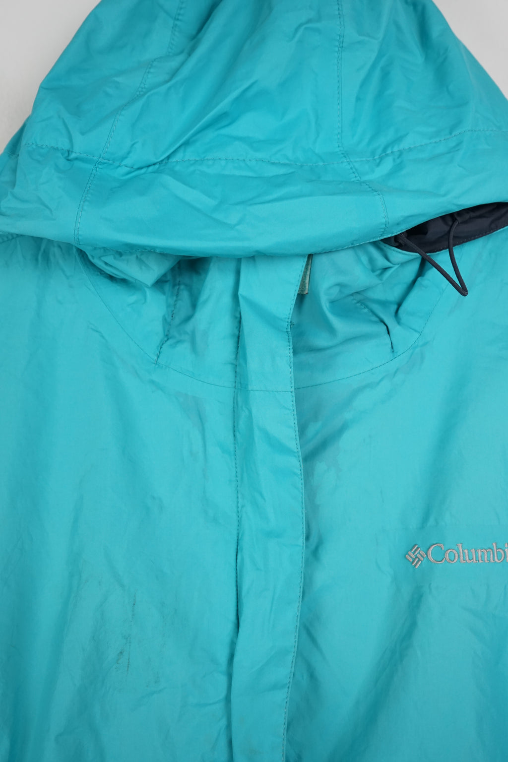 Turquoise jacket with a hood on a white background