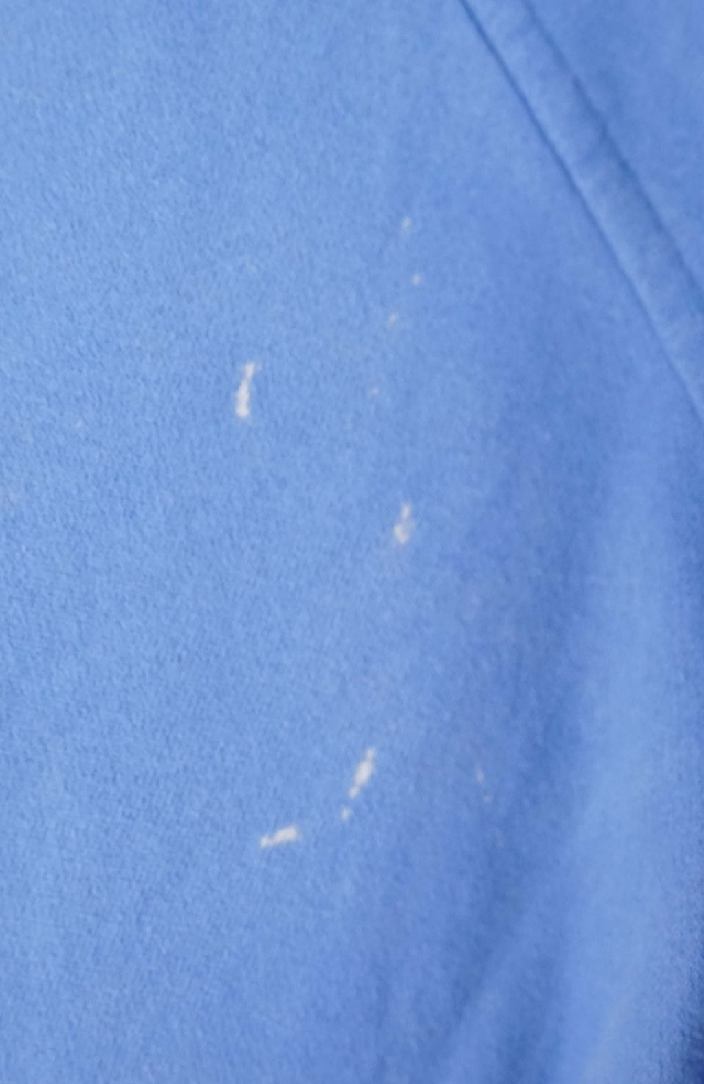 Blue sweatshirt on a white hanger against a white background