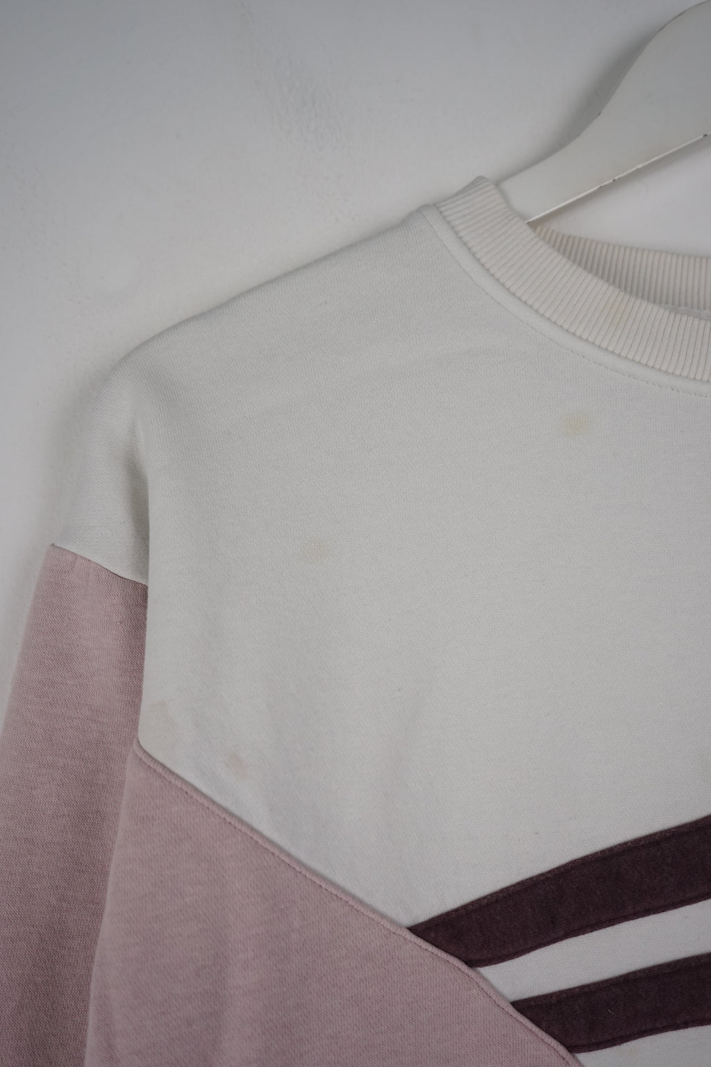 Pink Adidas sweatshirt with white stripes on a white background