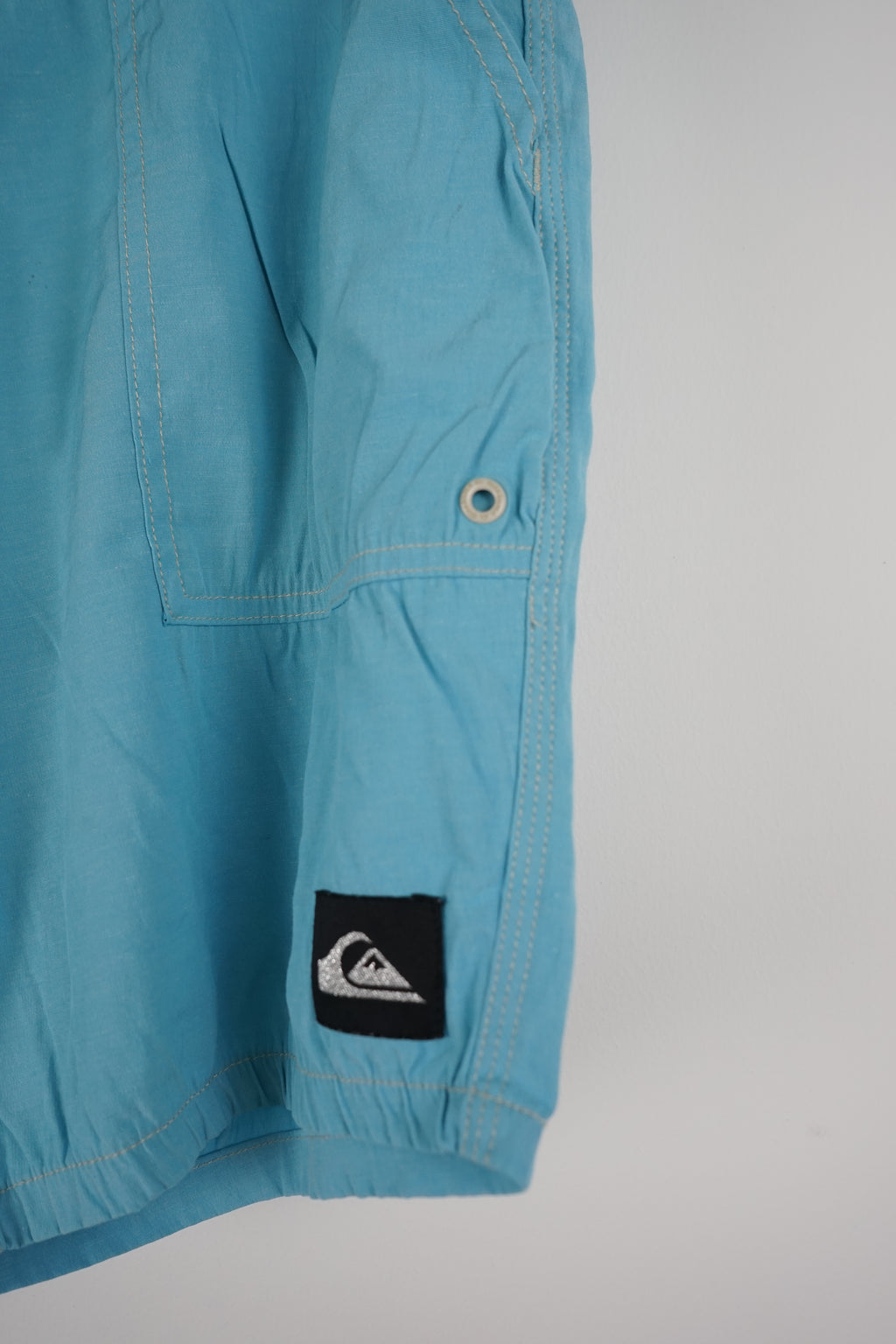 Light blue shorts with a brand logo on a white background