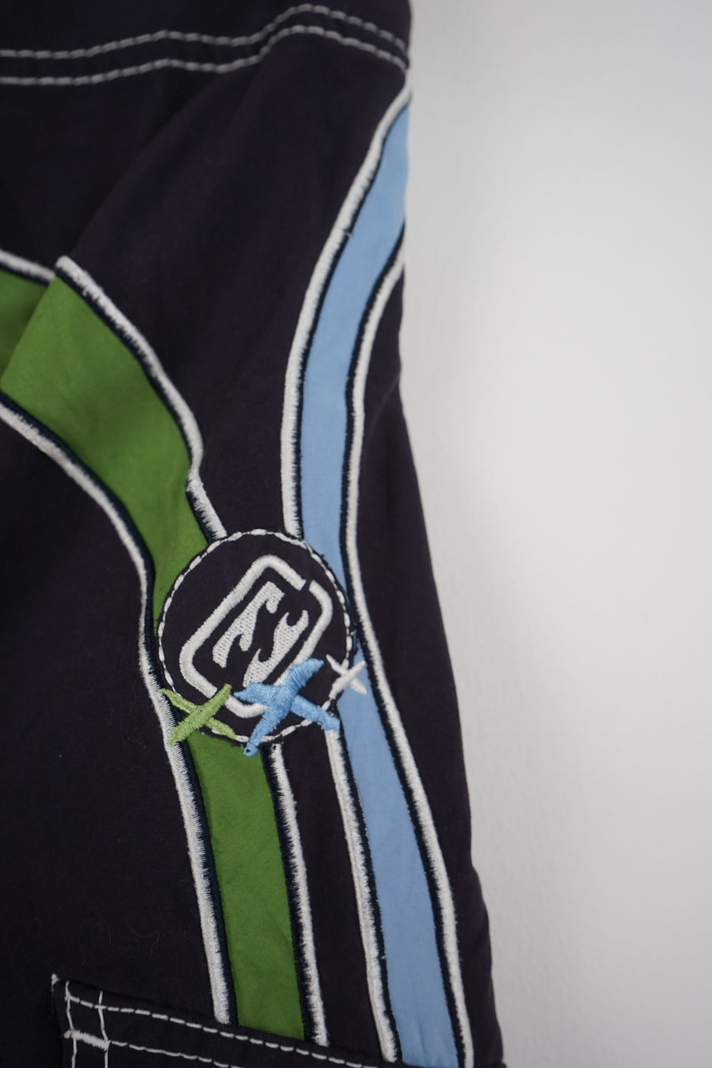 Black board shorts with blue and green accents on a white background