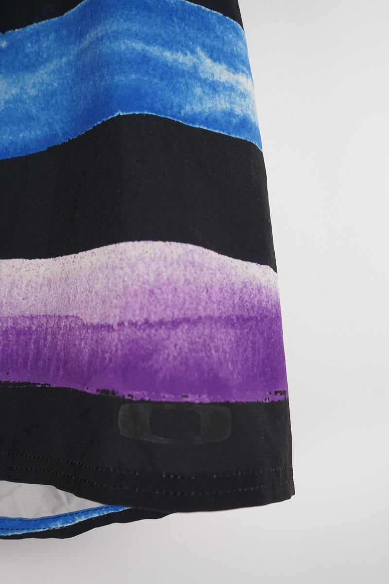 Close-up of a fabric with black, purple, and blue abstract pattern on a white background